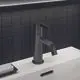 Waschtischarmatur in Dunkelgrau von Ideal Standard, mit einem schlichten Auslauf und einem lockeren Hebel zur Wassersteuerung, montiert auf einer weißen Ablage.